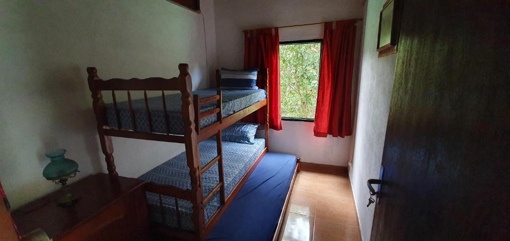 圣若泽-杜巴雷鲁CASA ACALANTA-Trilha das Flores-SERRA DA CANASTRA的小型客房设有两张双层床和窗户。