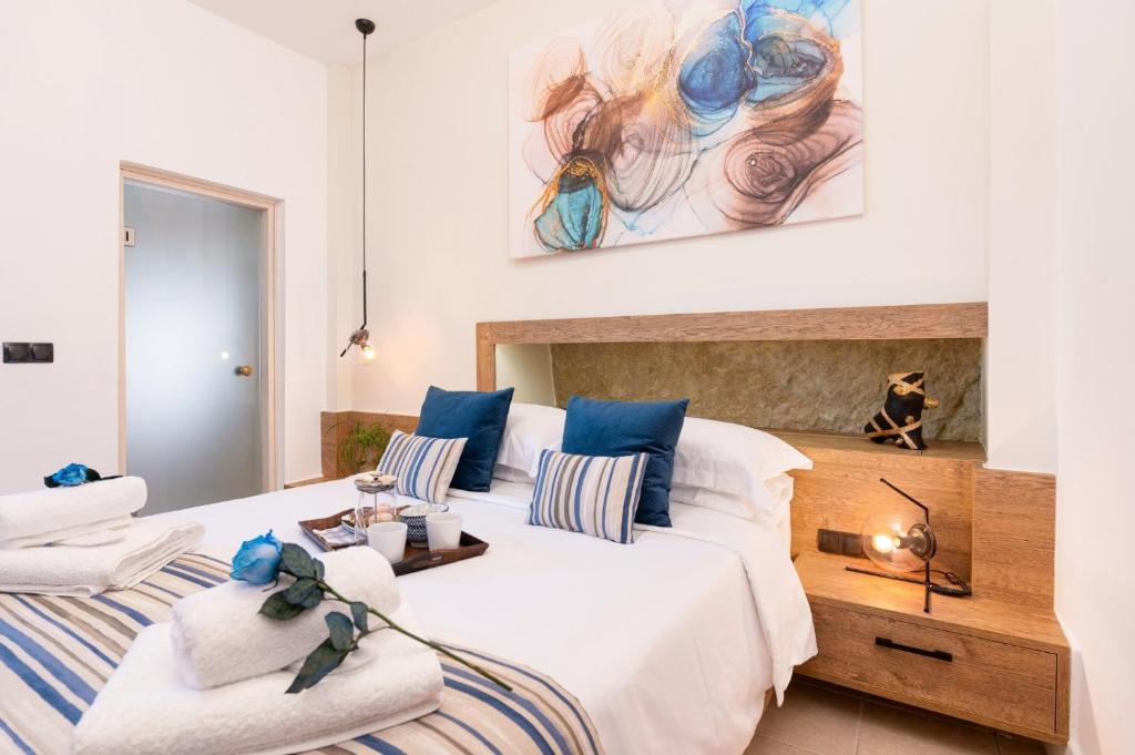 马塔拉MATALA * LUX CAVE的卧室配有一张蓝色色调的大型白色床。