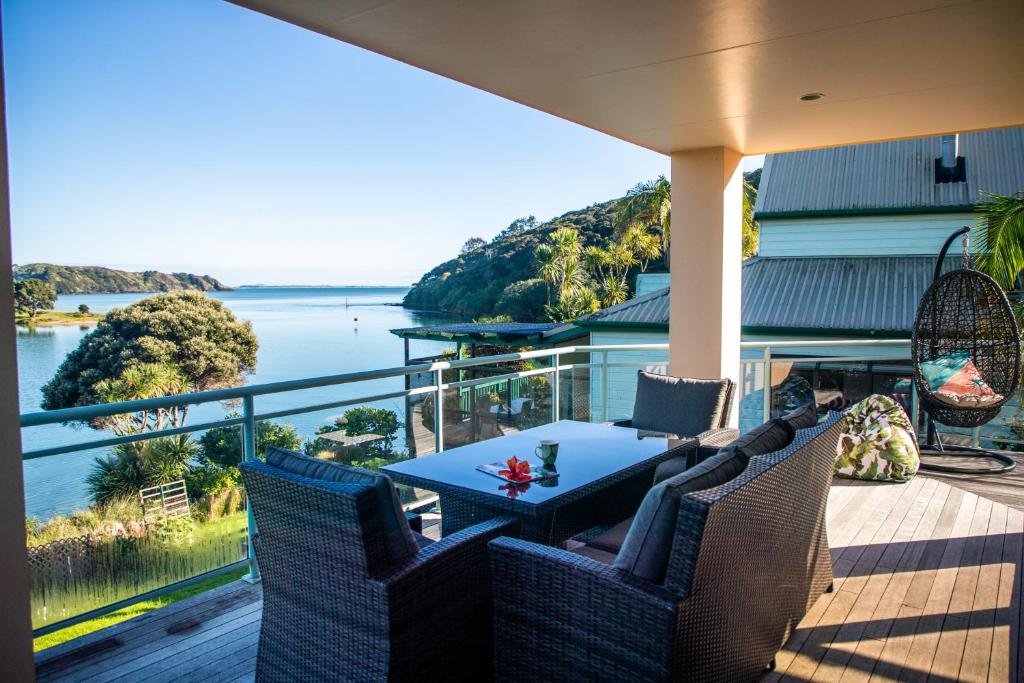 Cable BaySoul Retreat - Cable Bay Holiday Home的一个带桌椅的门廊,享有水景