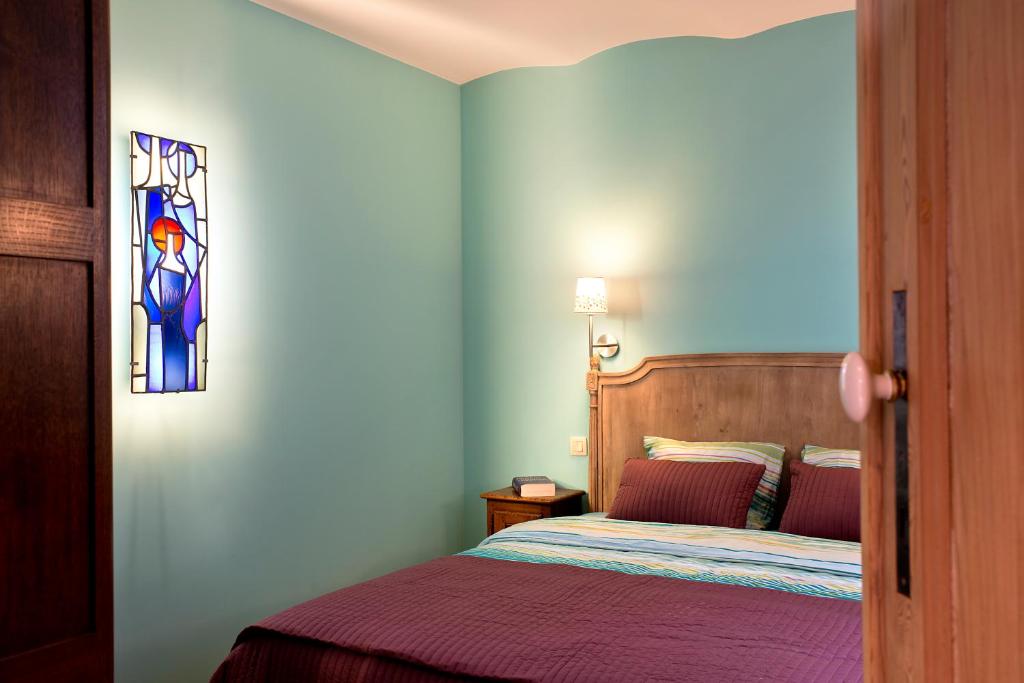 那慕尔里安乡村度假别墅酒店的一间卧室设有一张床和一个彩色玻璃窗