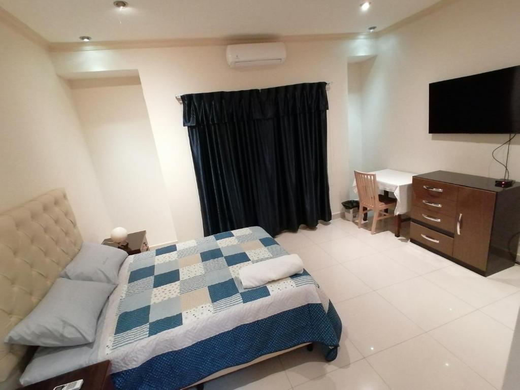 圣克鲁斯El Prado的一间卧室配有一张床、一张书桌和一台电视