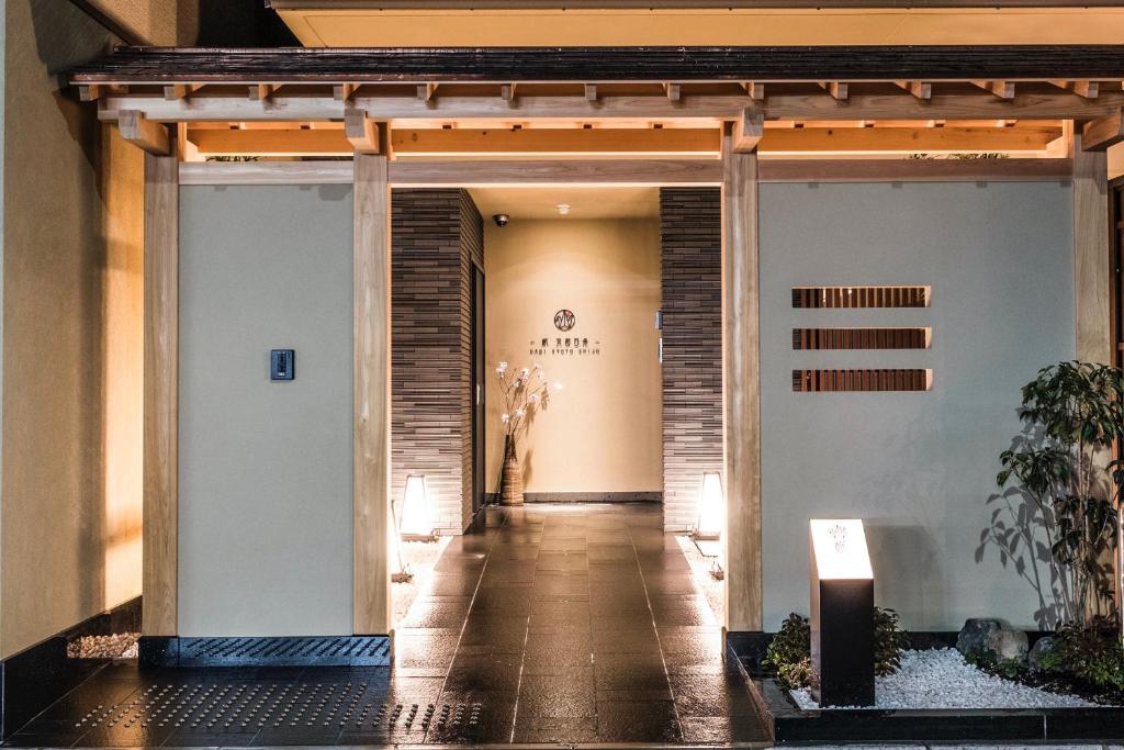 京都Homm Stay Nagi Shijo Kyoto By Banyan Group的走廊通往带入口的大楼