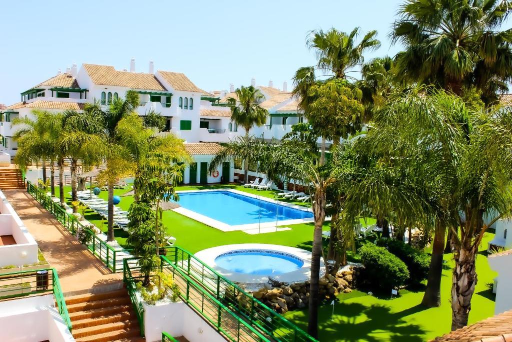 马尼尔瓦马尼尔瓦太阳公寓式酒店的享有度假村的空中景致,设有游泳池和棕榈树