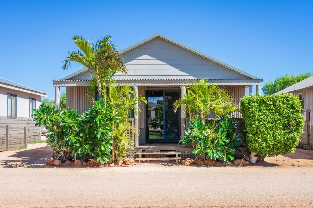 ExmouthNingaloo Caravan and Holiday Resort的前面有棕榈树的房子
