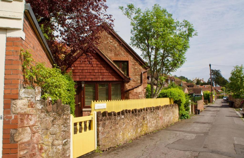 曼海德Minehead mews cottage的砖屋前的黄色围栏
