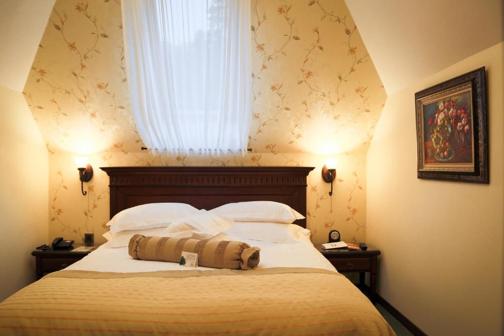 锡纳亚弗洛里酒店的一间卧室设有一张大床和窗户
