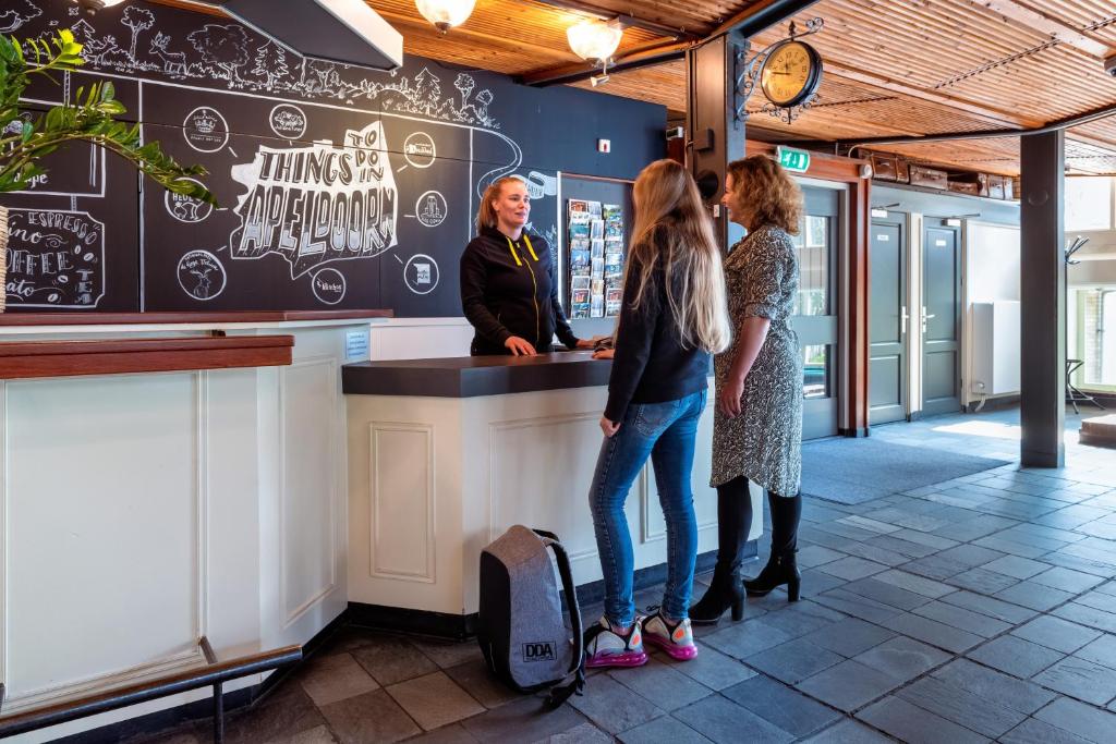 阿珀尔多伦Stayokay Hostel Apeldoorn的两名妇女在餐厅柜台站立