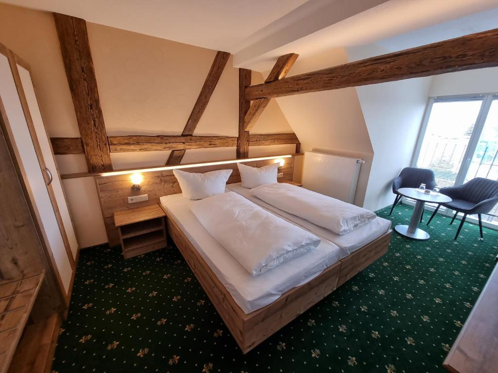 Peitz祖姆金狮酒店的一间卧室配有一张大床和一张桌子及椅子