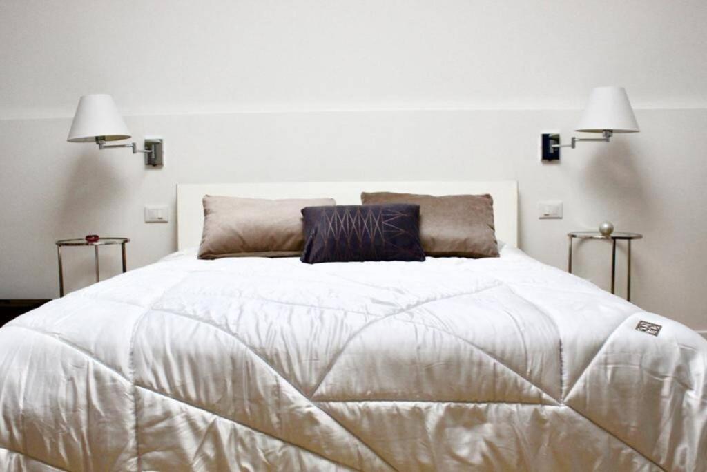 威尼斯Favola a Venezia的一间卧室配有一张带两盏灯的大型白色床。