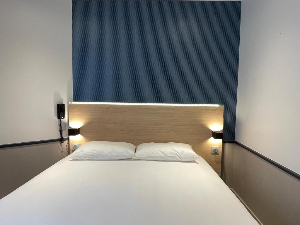巴黎圣日耳曼酒店的卧室配有一张带两个枕头的大白色床