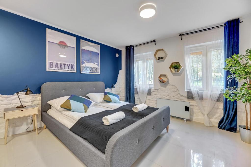 索波特Apartamenty przy Helskiej - Basement - Przyziemie的一间卧室配有一张蓝色墙壁的床