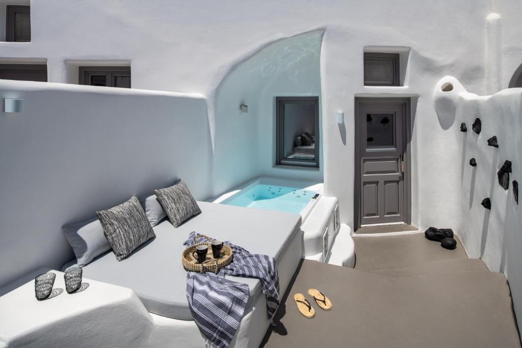 费拉Deep in cave suites的白色客房 - 带浴缸、床和鞋子