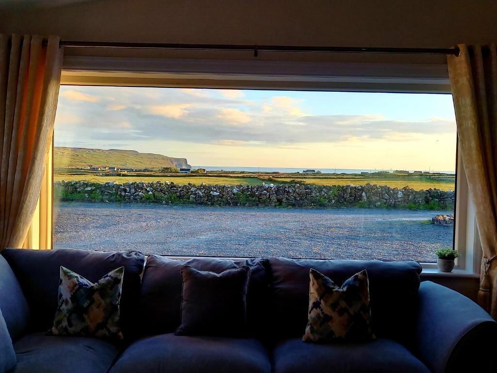 杜林Cliffs View Self Catering @ Limestone Lodge的一张沙发,坐在大窗户前