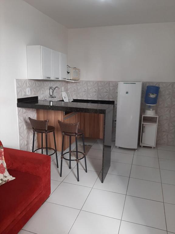 卡波布里奥Cantinho aconchegante 2 quartos, com ar condicionado的厨房配有柜台、椅子和冰箱