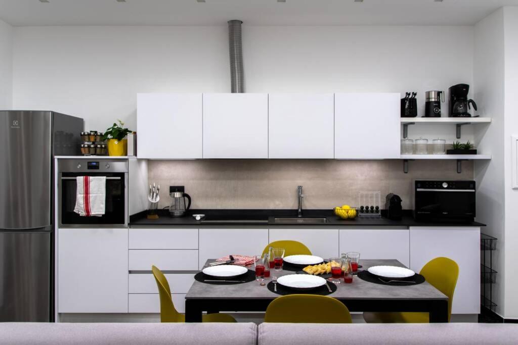阿尔本加LargoDoria - ViaArchivolto, box auto privato incluso的厨房配有白色橱柜和桌椅