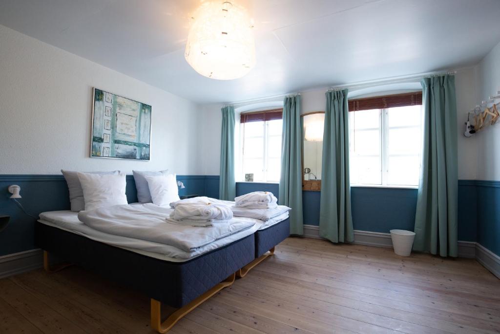 艾勒斯克宾布哈尼雅旅馆的一间卧室设有一张大床,拥有蓝色的墙壁和窗户。
