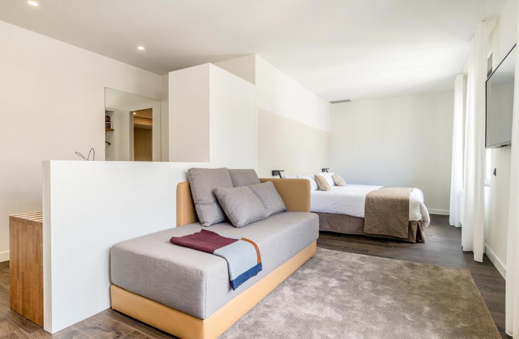 赫罗纳半岛酒店的一间卧室配有一张床和一个沙发