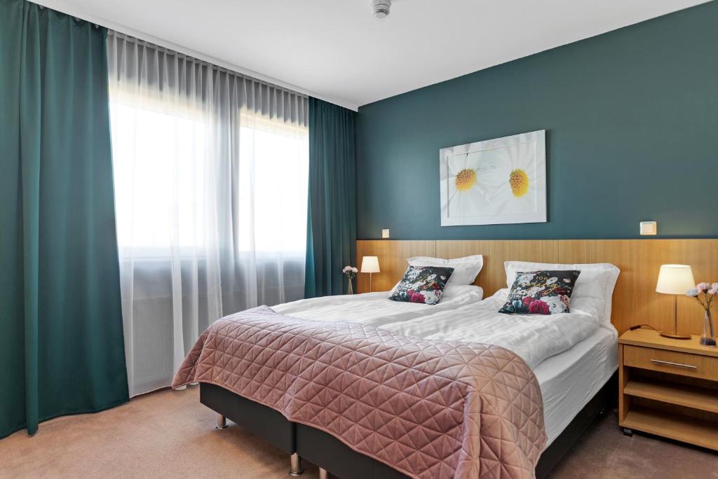 ÖlfusHotel Kvika的一间卧室配有一张带蓝色墙壁的大床