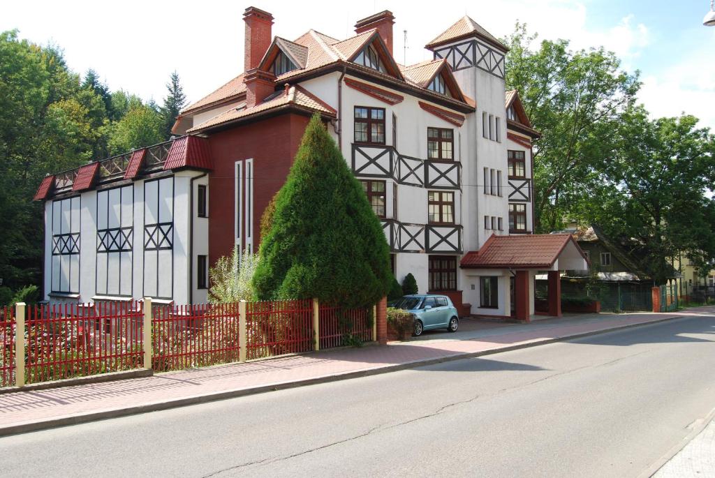 克雷尼察FAMILIJNY Ośrodek Wypoczynkowo - Rehabilitacyjny Krynica Zdrój的一座白色和红色的大房子,带有红色的栅栏