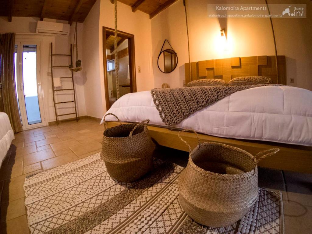艾拉方索斯Kalomoira's Apartments的卧室配有一张带篮子的床铺,位于地板上
