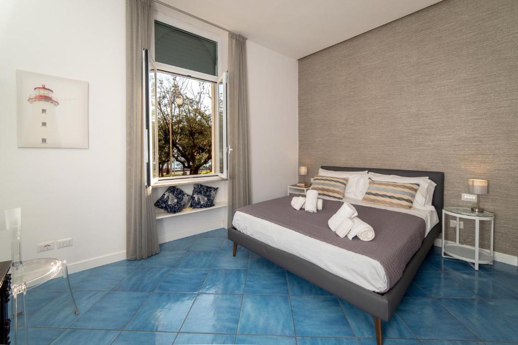 萨莱诺Suitesettepesciolini - Case vacanze Nemo e Dory的一间卧室配有一张蓝色地板和窗户。