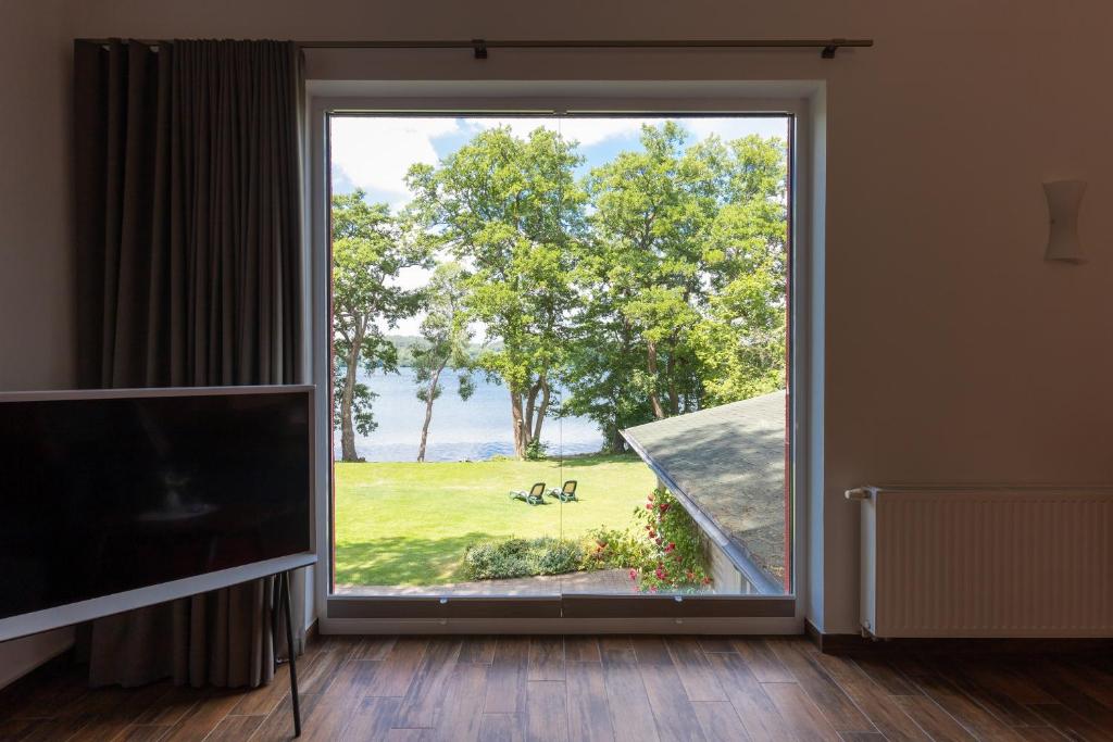 利兴Seehotel Lindenhof的客厅设有大窗户,享有公园美景