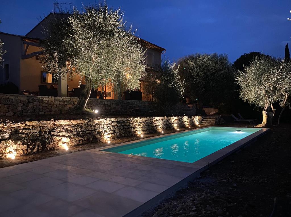 勒鲁雷Mas de charme au milieu des oliviers的夜间后院的游泳池