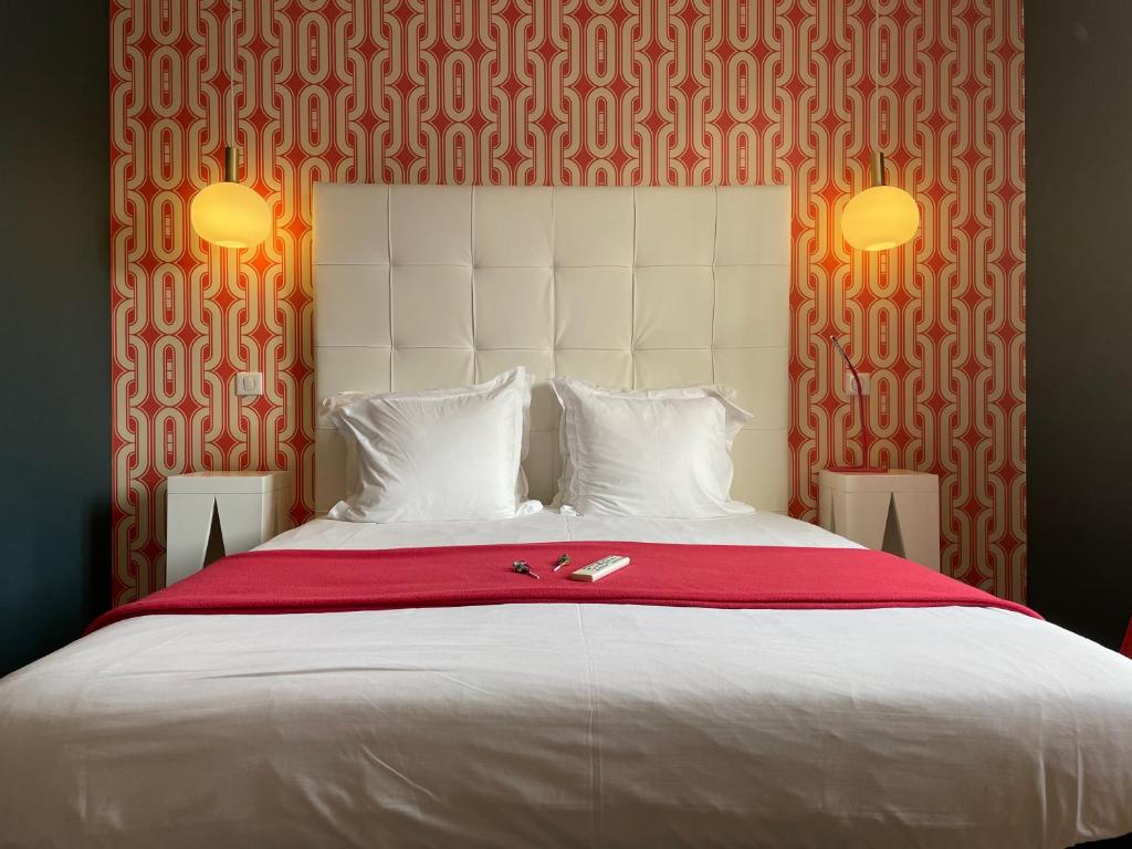 比亚里茨米拉诺酒店的卧室配有一张大白色床和红色毯子