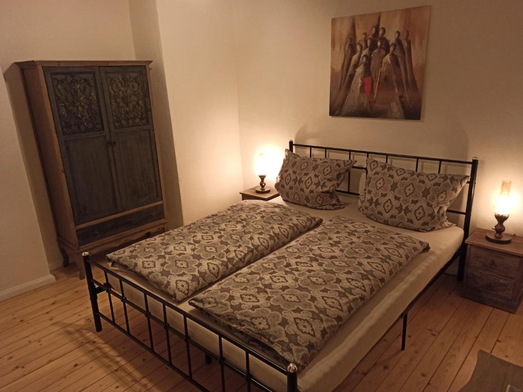 葡萄酒之路上的诺伊施塔特Alte Schmiede Neustadt的卧室配有一张床,地板上配有两盏灯