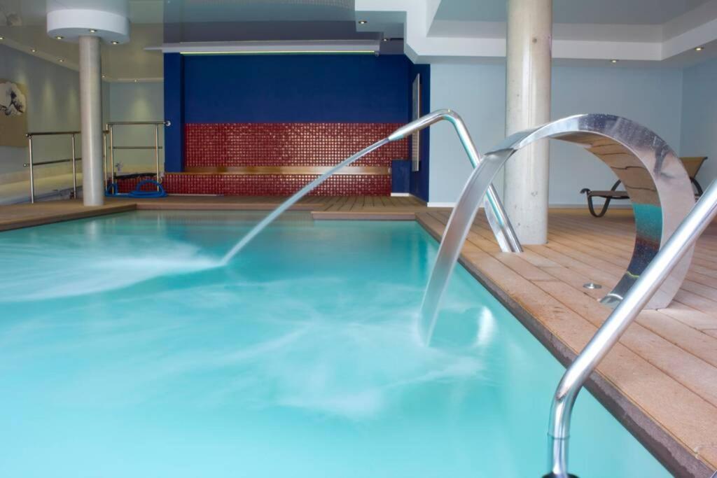 诺哈Centrico apartamento en Noja con acceso a Spa的一座大楼内带水滑梯的游泳池