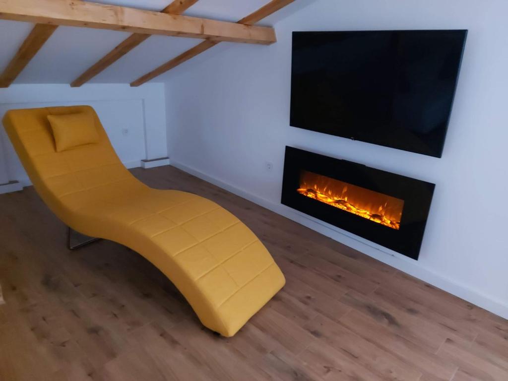 奥赫里德Villa Passage的带壁炉的客房内的黄色椅子