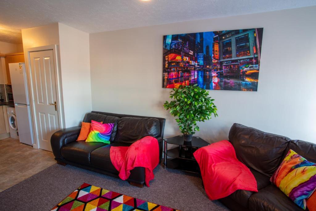 沃灵顿Ample Comforts, Centrally Located, Town Centre的客厅配有两张带彩色枕头的真皮沙发