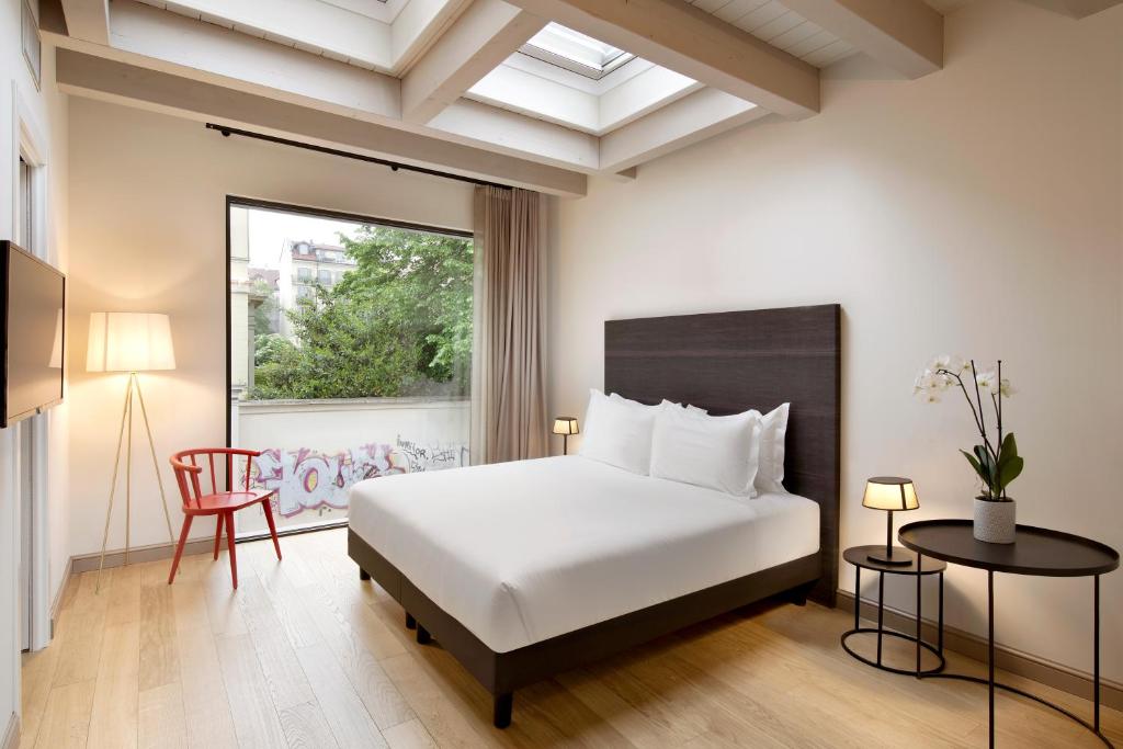 都灵Opera35 Boutique Hotel的卧室配有白色的床和窗户。