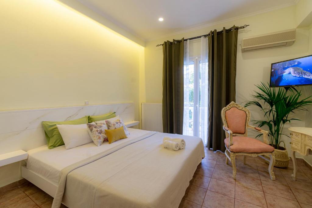 卡拉马孔Villas Margaris的卧室配有一张白色大床和一把椅子