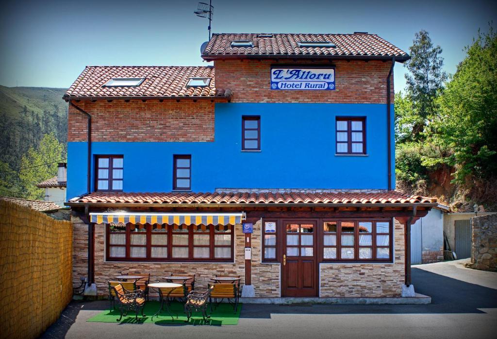 努埃瓦德兰斯月桂树酒店的蓝色的建筑,前面设有桌椅