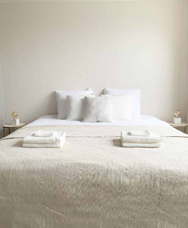 登堡Sea you soon的一张白色的床,上面有两个白色的枕头