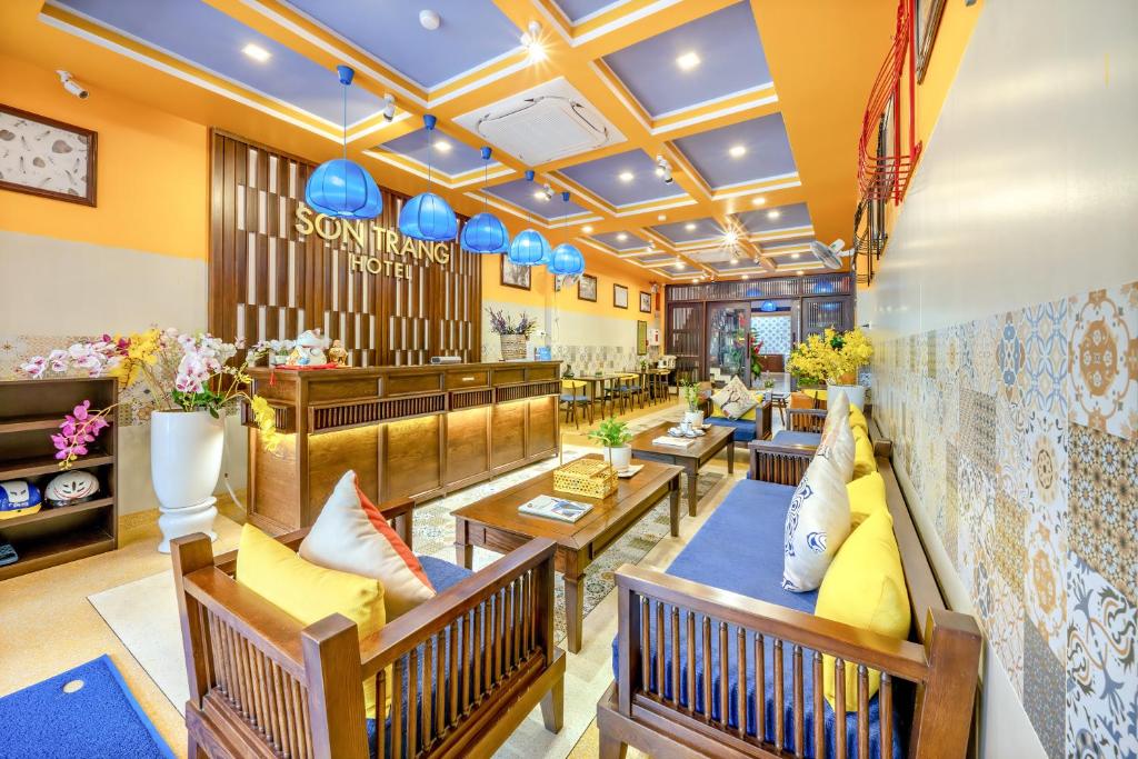 会安Son Trang Hotel Hoi An的餐厅设有长椅、桌子和蓝色灯具