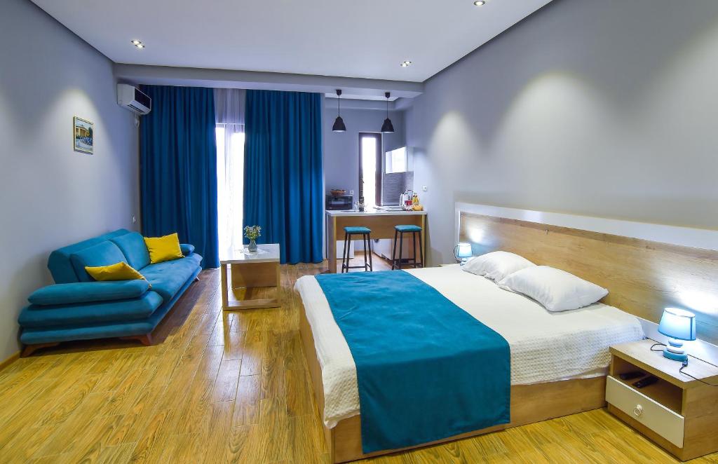 库塔伊西Our Apartment的一间卧室配有一张大床和一张蓝色的沙发
