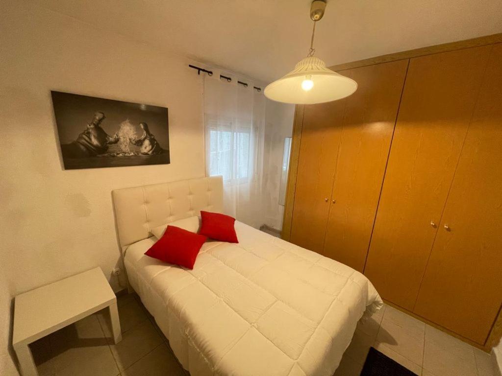 马德里Valdavia Habitaciones的卧室配有白色床和2个红色枕头