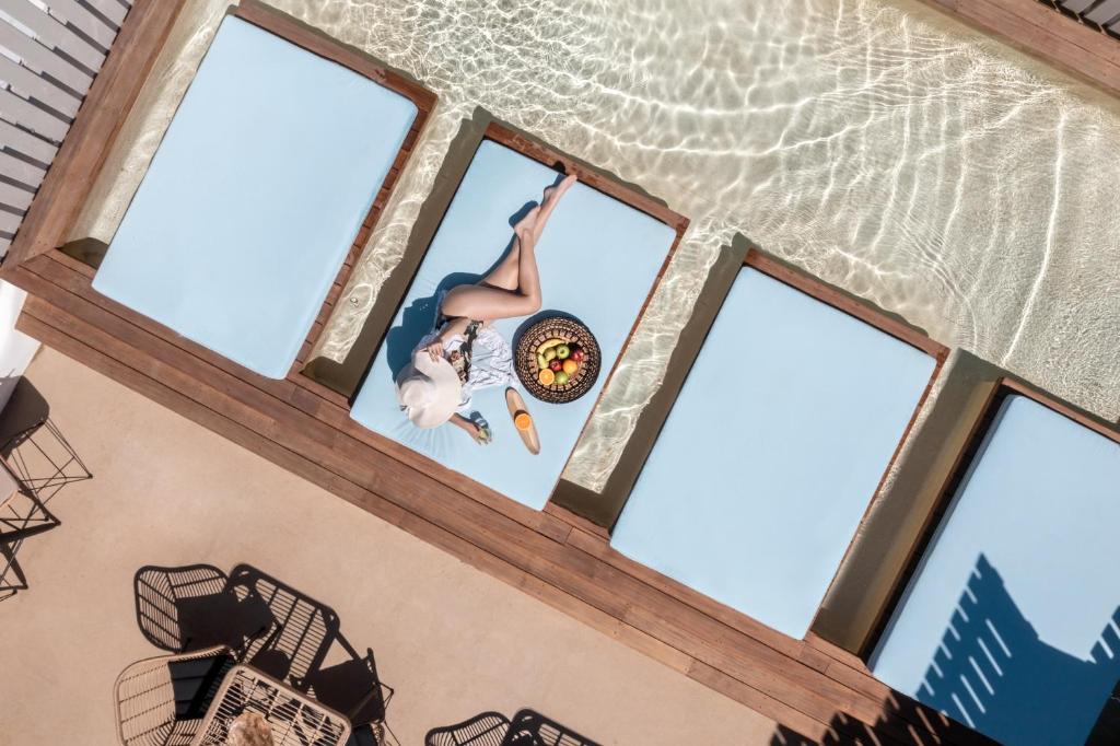 纳克索乔拉阿尔戈精品酒店的一个人在窗前的蹦床上玩弄花招