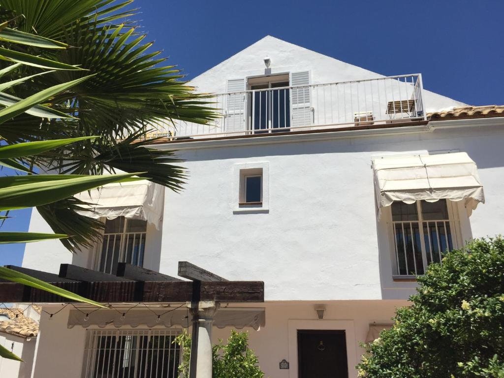格拉纳达San Miguel B&B Granada的带阳台的白色建筑和棕榈树