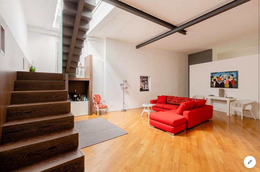 巴里Bijoux Luxury Apartment in Old Town的一间带红色沙发的客厅和楼梯