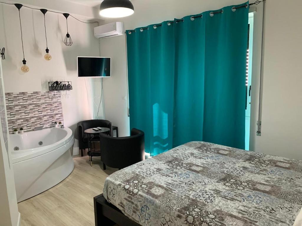福尔米亚Luxury Suite Aurora的带浴缸和蓝色淋浴帘的浴室