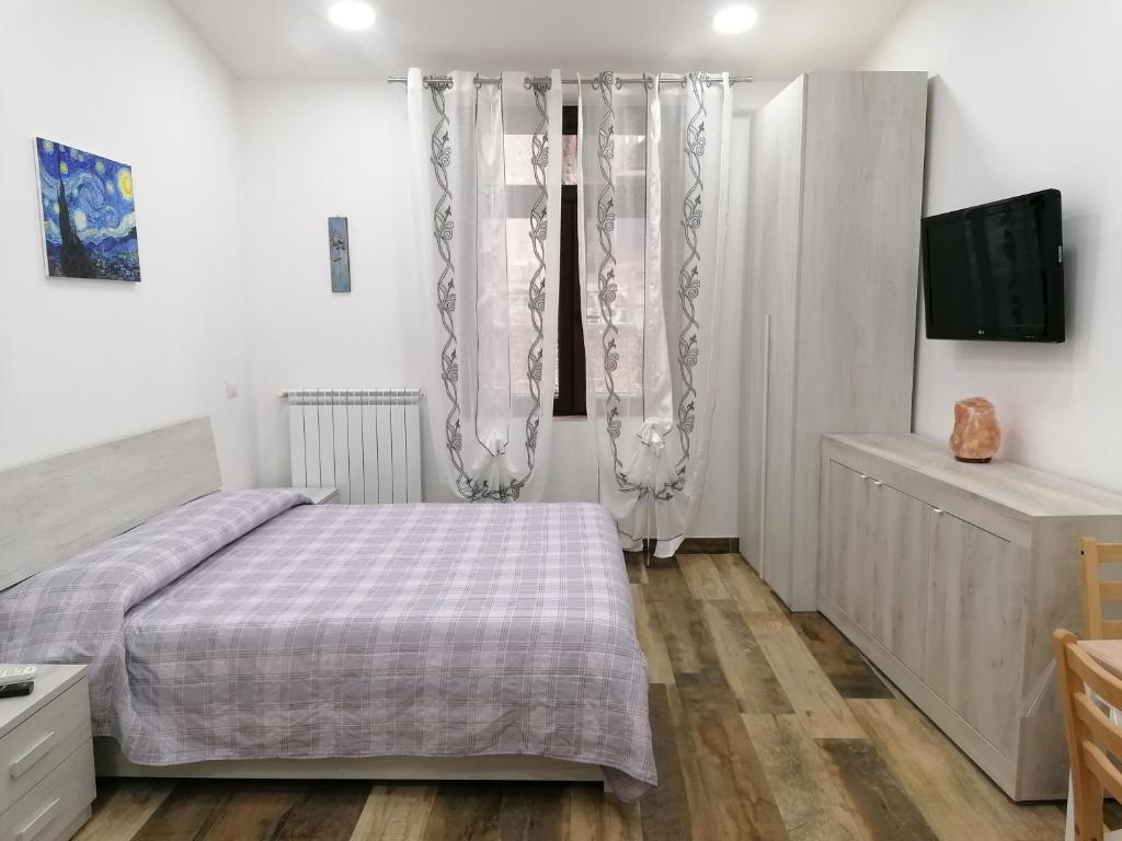 卡普拉罗拉IL Cavour的一间卧室配有床和带窗帘的窗户
