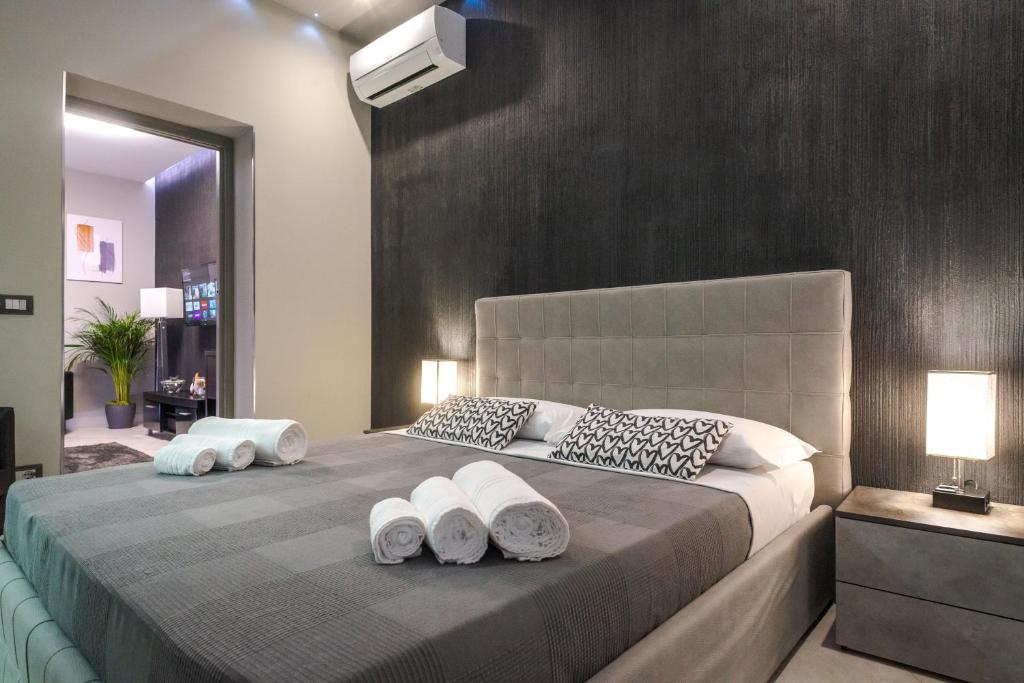 卡塔尼亚Suite Catania Lungomare的一间卧室配有一张大床和两条毛巾