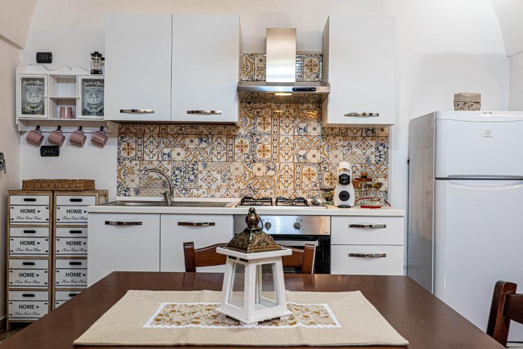 迪索NONNA VALERIA的厨房配有白色橱柜和木桌