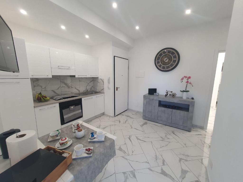 贾迪尼-纳克索斯GioRi的厨房配有白色橱柜和瓷砖地板。