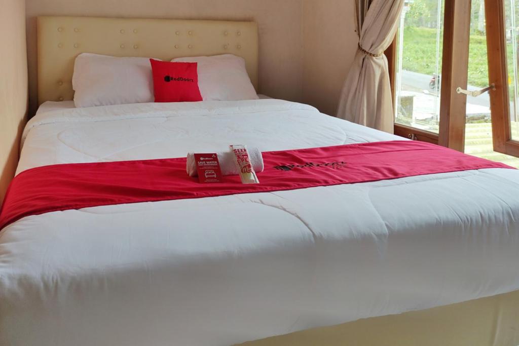 沃诺索博RedDoorz near Agrowisata Kebun Teh Dieng的一张带红色毯子的白色床和两个盒子