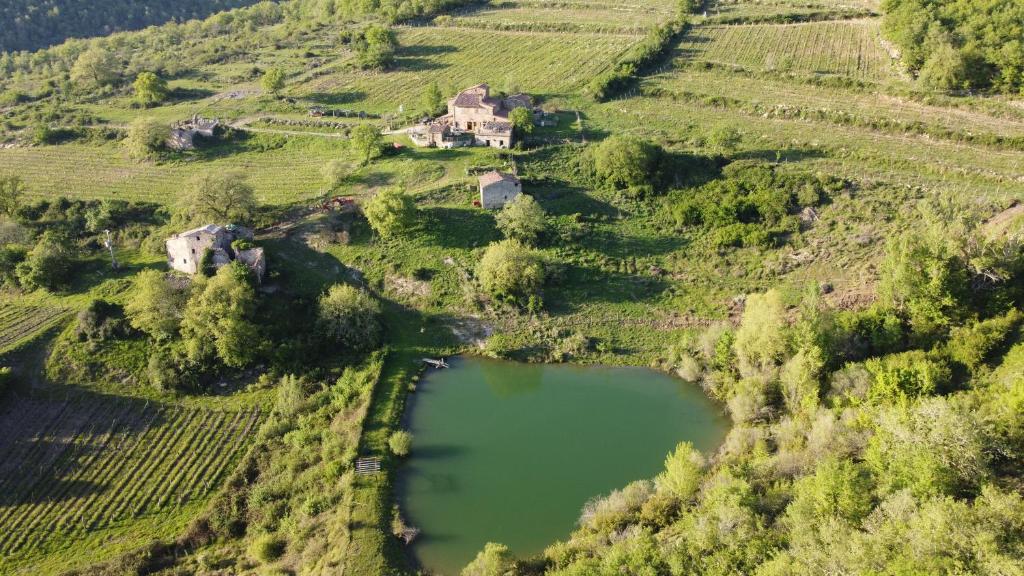 拉达-因基安蒂Agriturismo Podere Tegline的享有湖畔山丘上房屋的空中景致