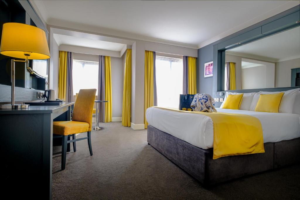 克莱尔戈尔韦克莱尔戈尔韦酒店的酒店客房设有一张大床和一张书桌。